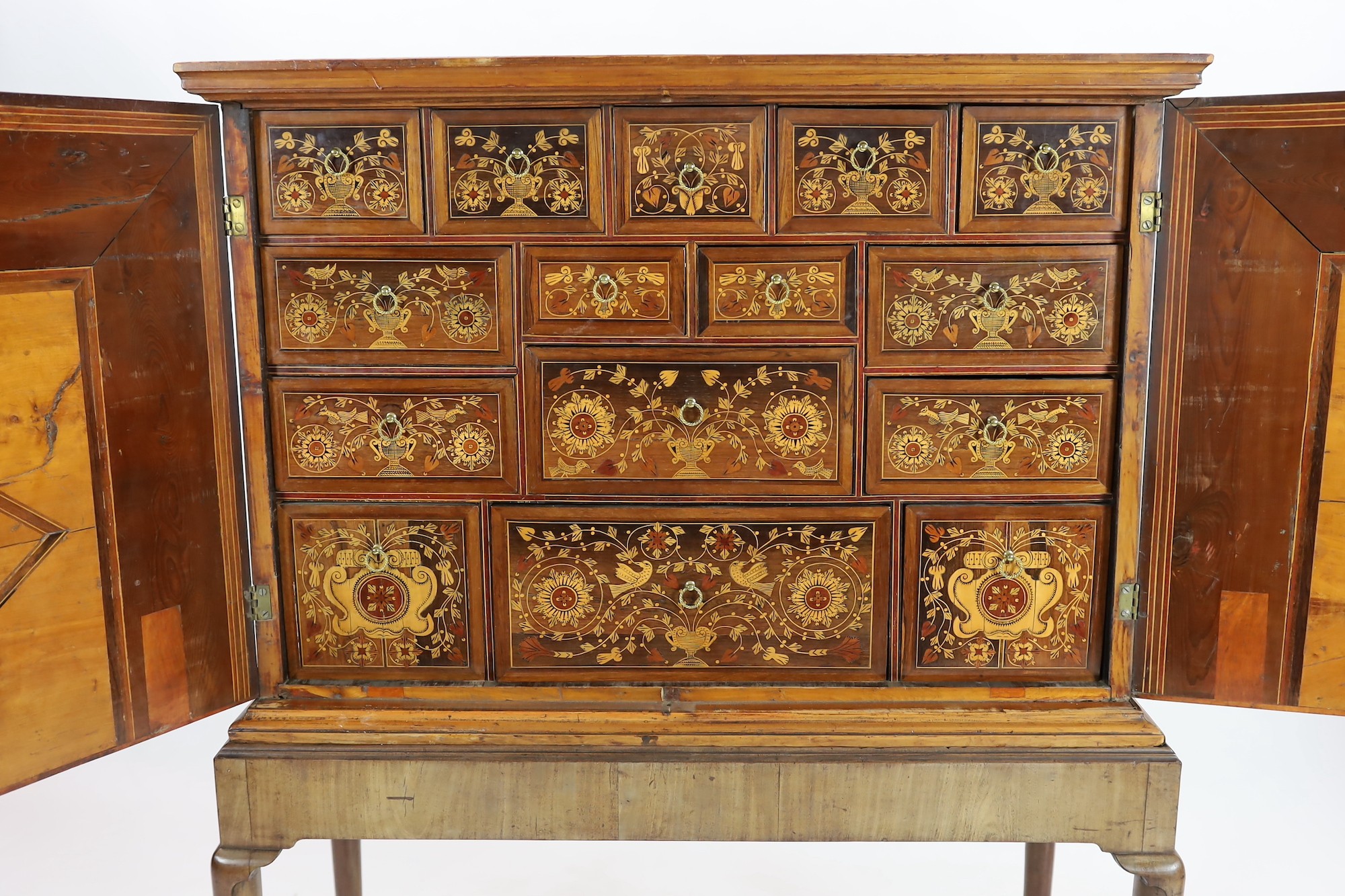 A 17th century and later South German walnut and marquetry cabinet on later stand, width 110cm, depth 53cm, height 153cm